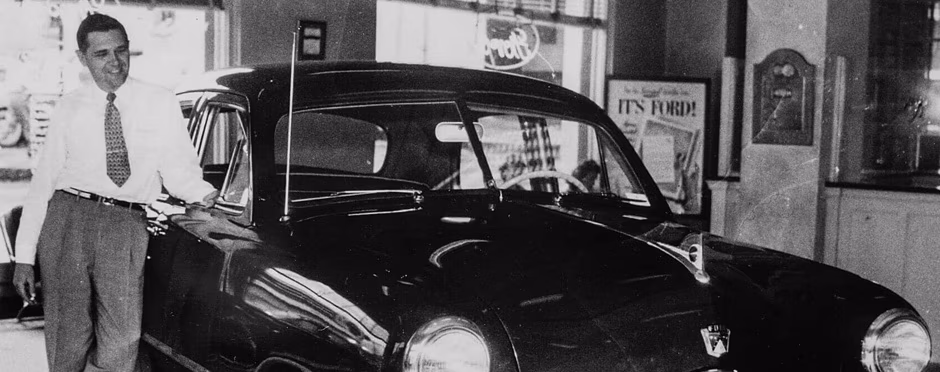 Salesman poses with latest Ford model